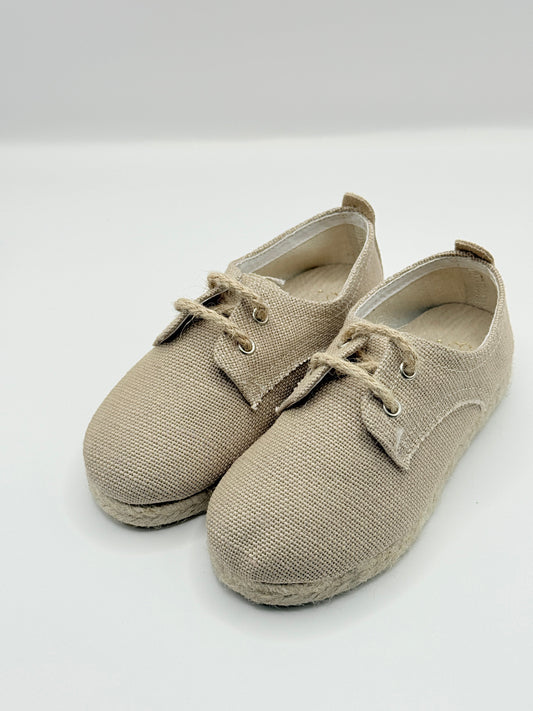 Pair of beige shoes on a light gray background