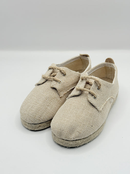 Pair of beige baby shoes on a white background
