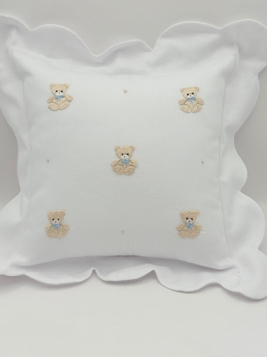 Decorative pillow with embroidered designs on a plain background